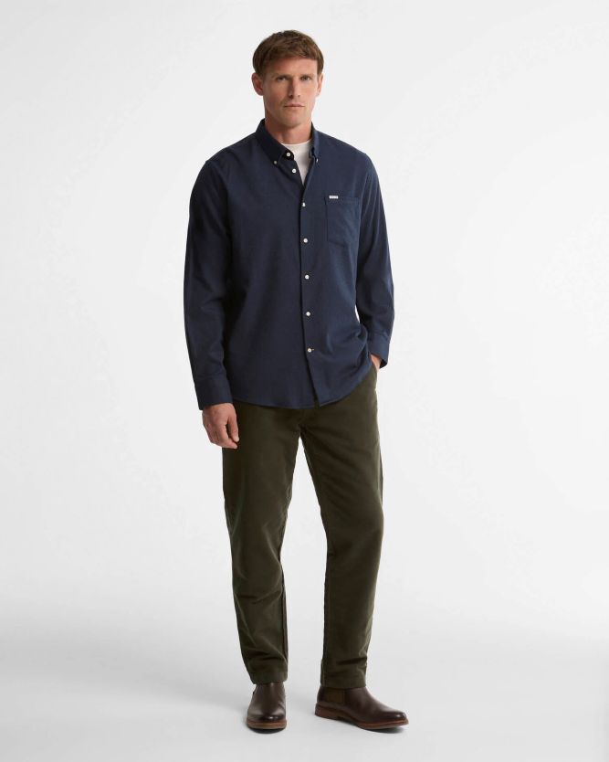 Navy button-down shirt, olive corduroy pants, and brown leather chelsea boots styled